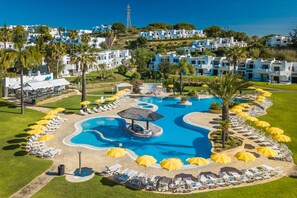 A resort with a swimming pool, sun loungers, and umbrellas. - Clube Albufeira Garden Village (Albufeira)