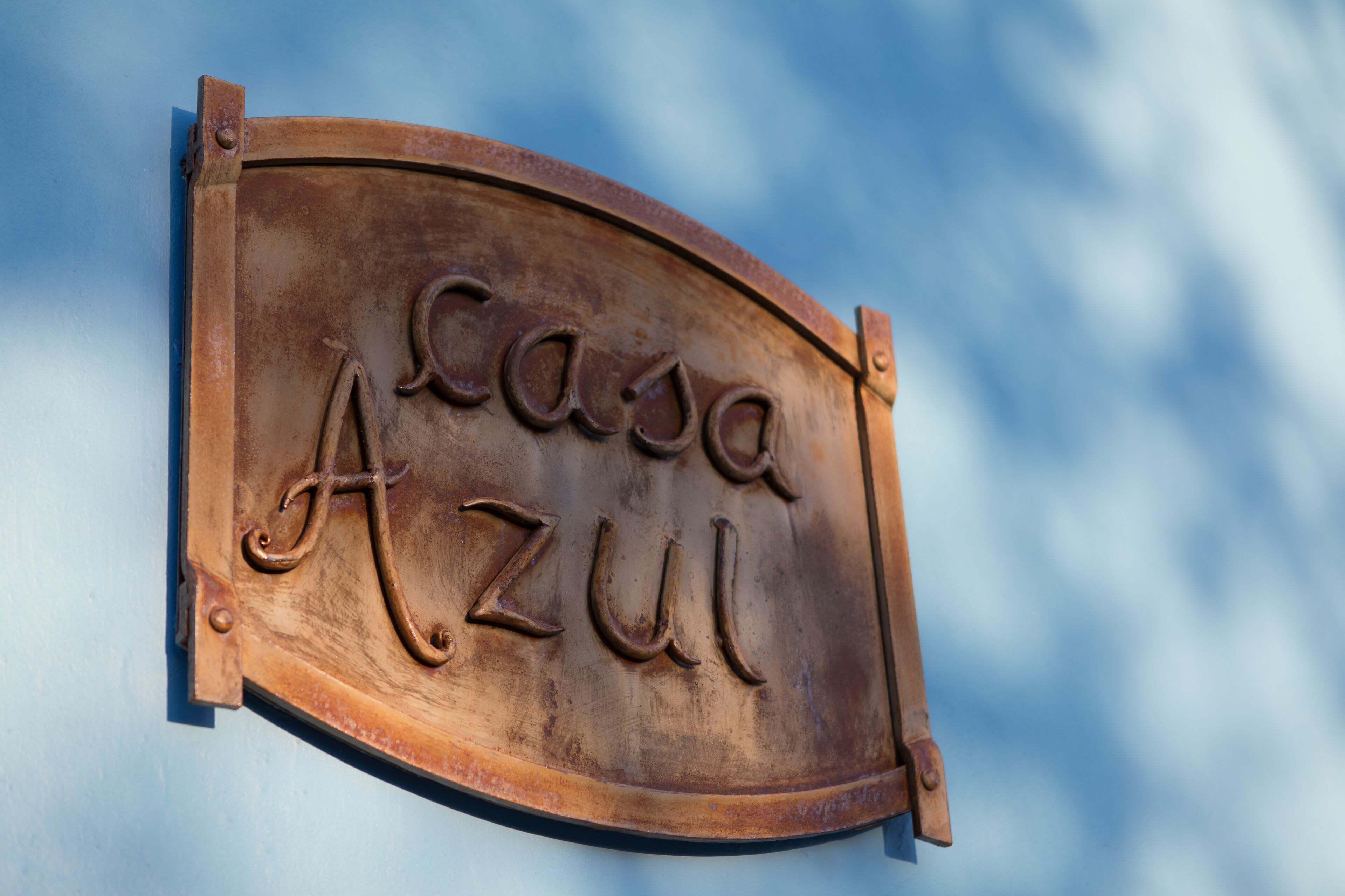 A metal sign with the inscription "Casa Azul" mounted on a wall.