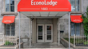 The entrance to EconoLodge, a hotel with a prominent red sign and two smaller signs indicating the hotel's name. - Econo Lodge (Montreal)