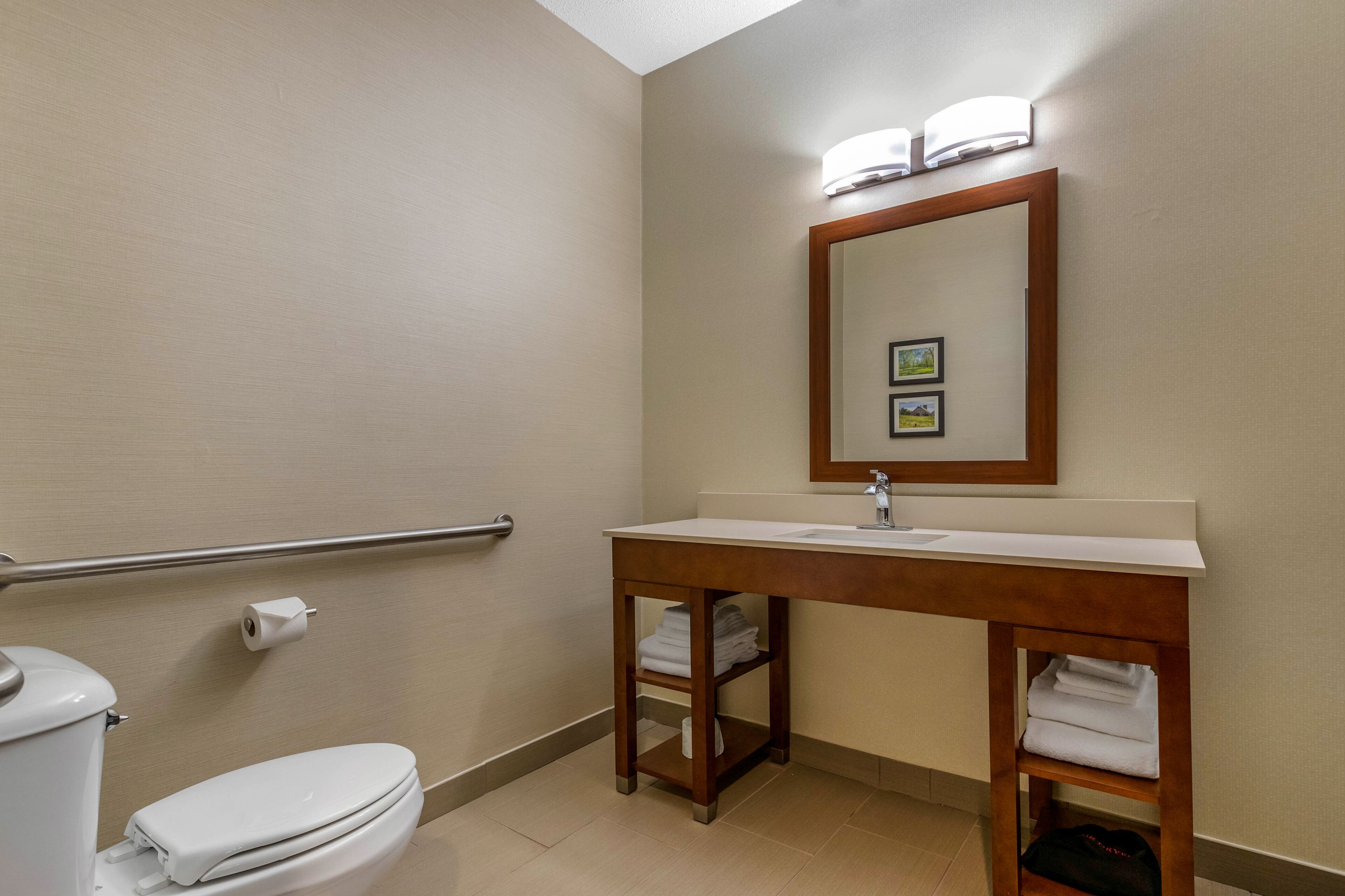 Une salle de bain avec des toilettes, un lavabo et un miroir.