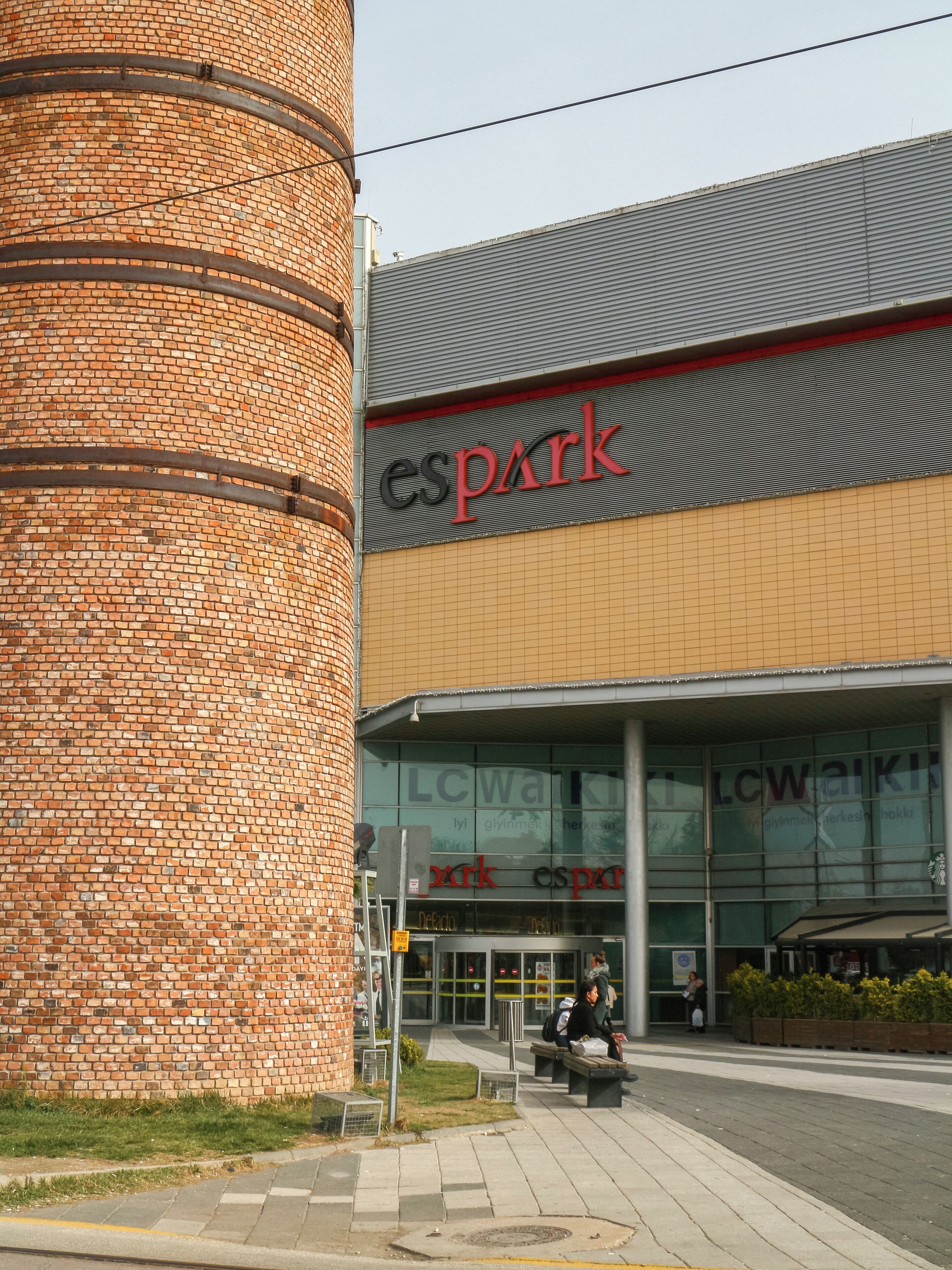 Un edificio de ladrillo con una gran torre cilíndrica y un letrero que dice "espark".