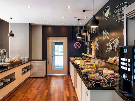 A modern breakfast bar with a variety of food options, a coffee machine, and a chalkboard menu.. ibis Eskisehir