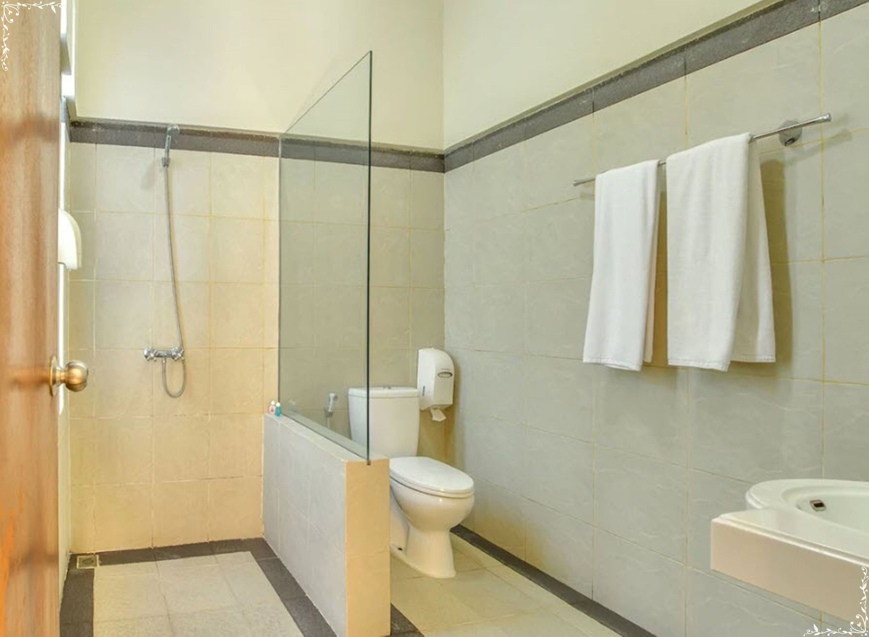 A bathroom with a glass-enclosed shower, a toilet, and a sink.