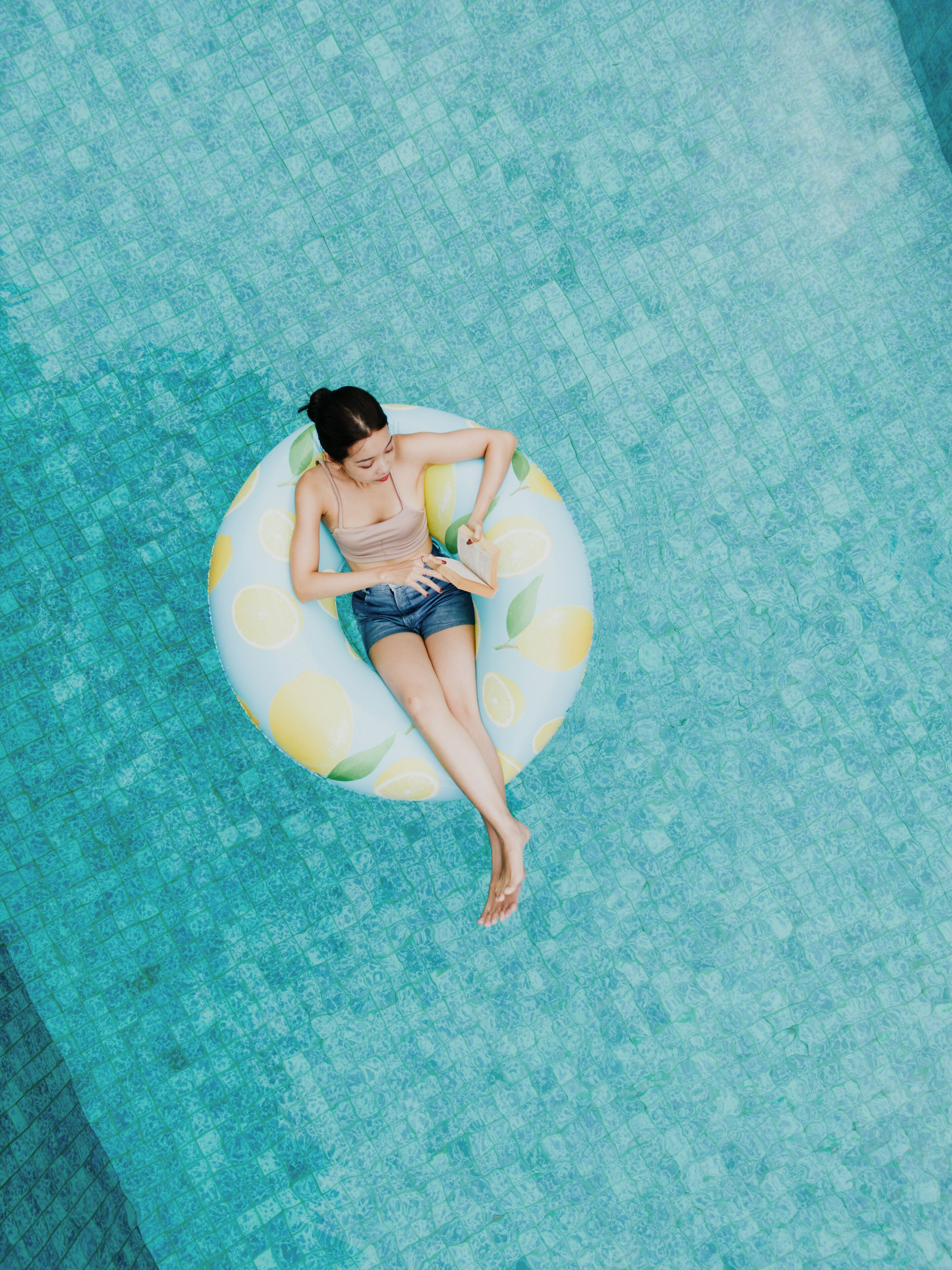 Una persona recostada en un flotador en una piscina.
