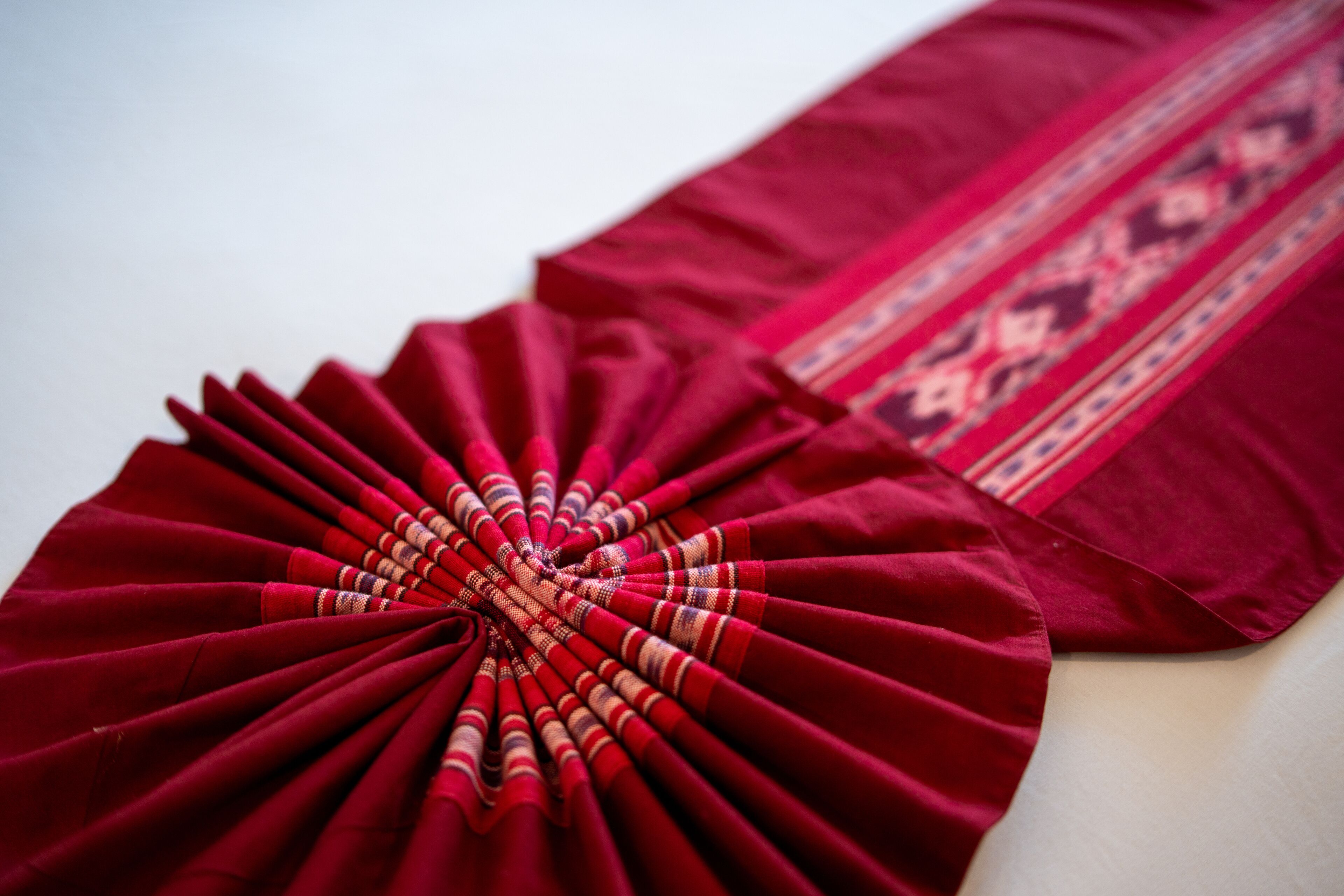 A close-up of a red fabric with a patterned border.