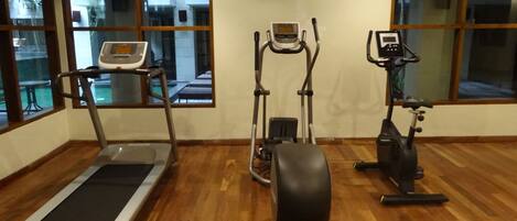A gym with a treadmill, elliptical, and stationary bike.