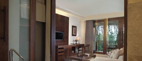 Un baño moderno con una bañera independiente, un tocador de madera y un televisor montado en la pared.