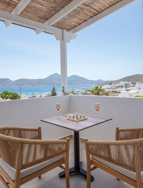 A terrace with wicker chairs, a table, and two glasses of champagne.
