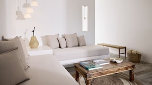 Una sala de estar moderna con un sofá, una mesa de centro y lámparas colgantes.
