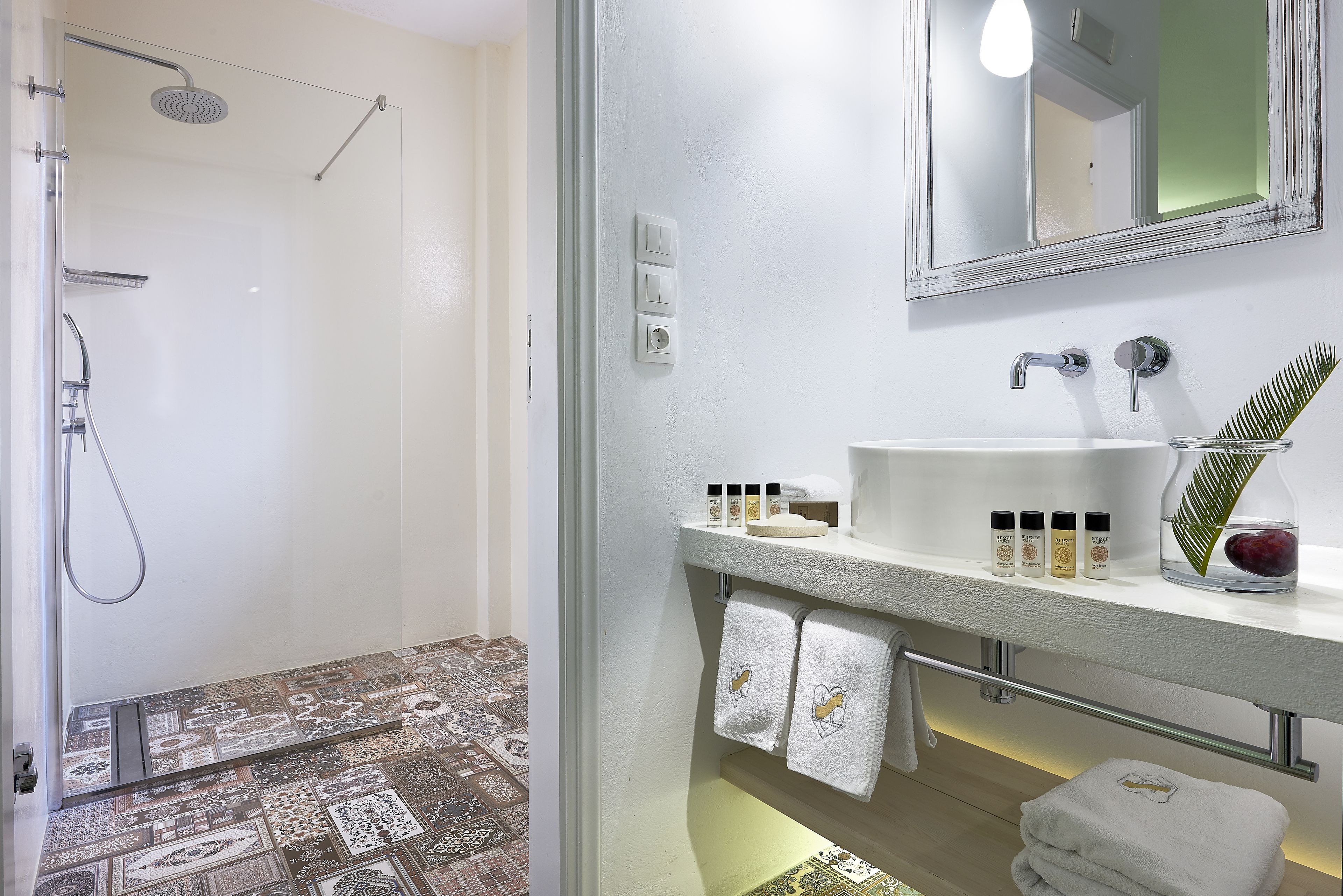 A bathroom with a shower, a sink, and a mirror.