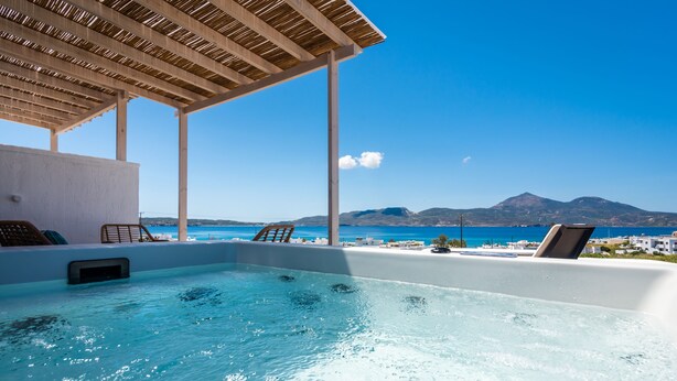 Una piscina infinita en la azotea con vistas al mar y a las montañas.
