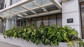 A modern building with a glass entrance, number 321, and a planter with tropical plants. - Píer Vitória Hotel (Vitoria)
