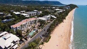 A coastal resort with multiple buildings, a beach, and a road. - Sea Change Beachfront Apartments (Trinity Beach)