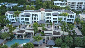 A resort with multiple buildings, outdoor pools, and palm trees. - Sea Change Beachfront Apartments (Trinity Beach)