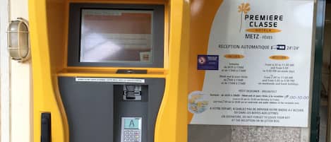 Un quiosco amarillo de autoservicio para el registro en un hotel.