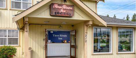Un edificio con un letrero que dice "Three Rivers Inn Lobby" y el número "210" en la parte lateral.