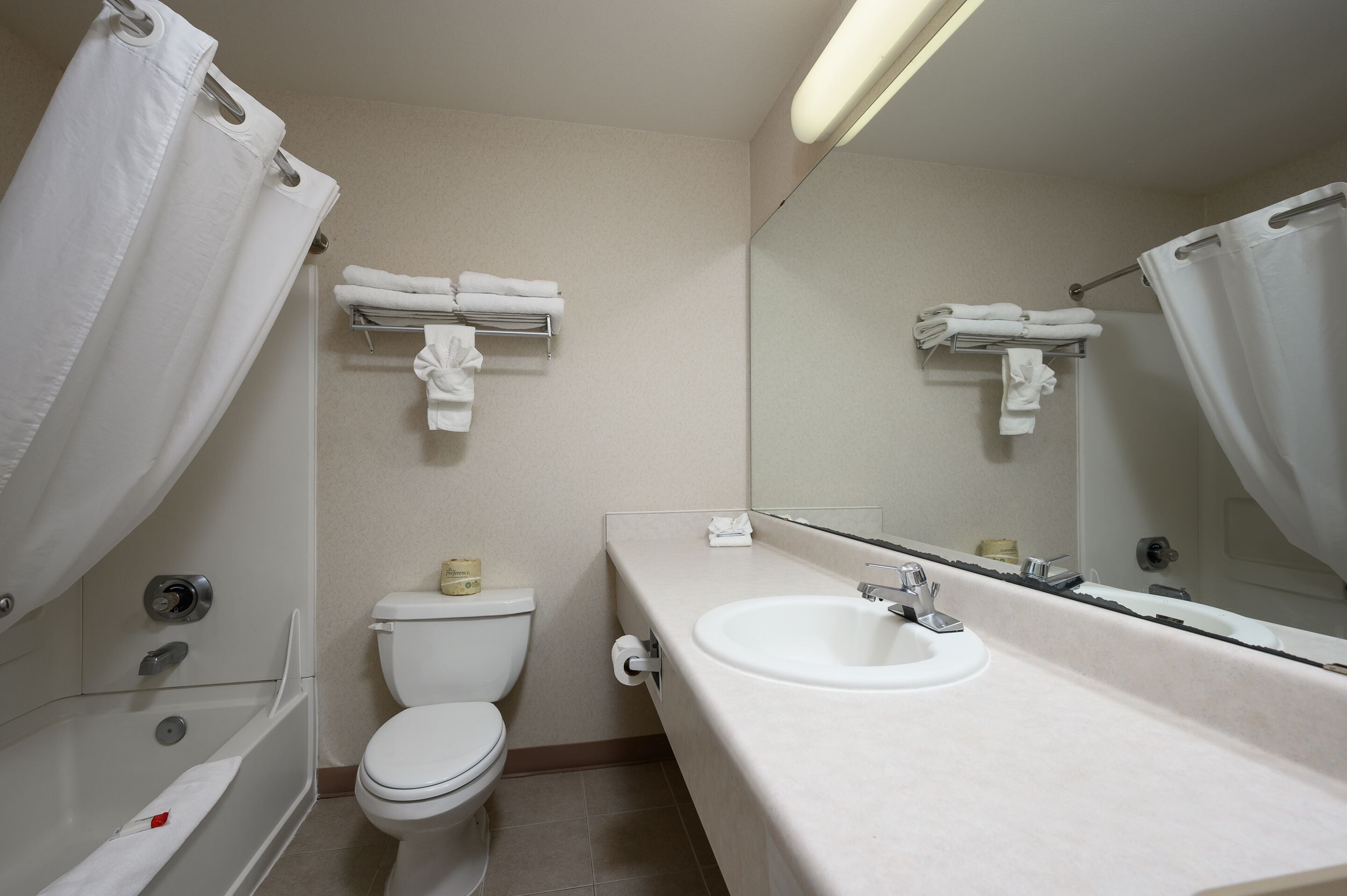 A bathroom with a toilet, sink, and shower.