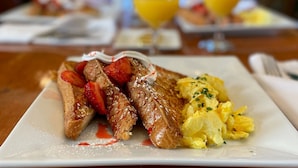 A breakfast plate with French toast, strawberries, whipped cream, and scrambled eggs. - Cleveland House (Newport)