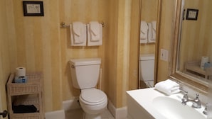 A bathroom with a toilet, sink, and two towels hanging on the wall. - Cleveland House (Newport)