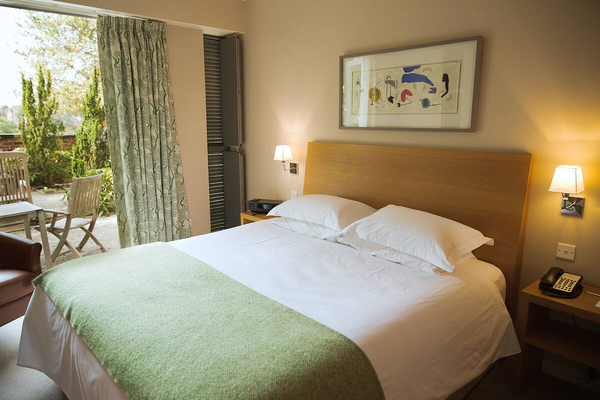 A hotel room with a bed, a desk, and a chair.