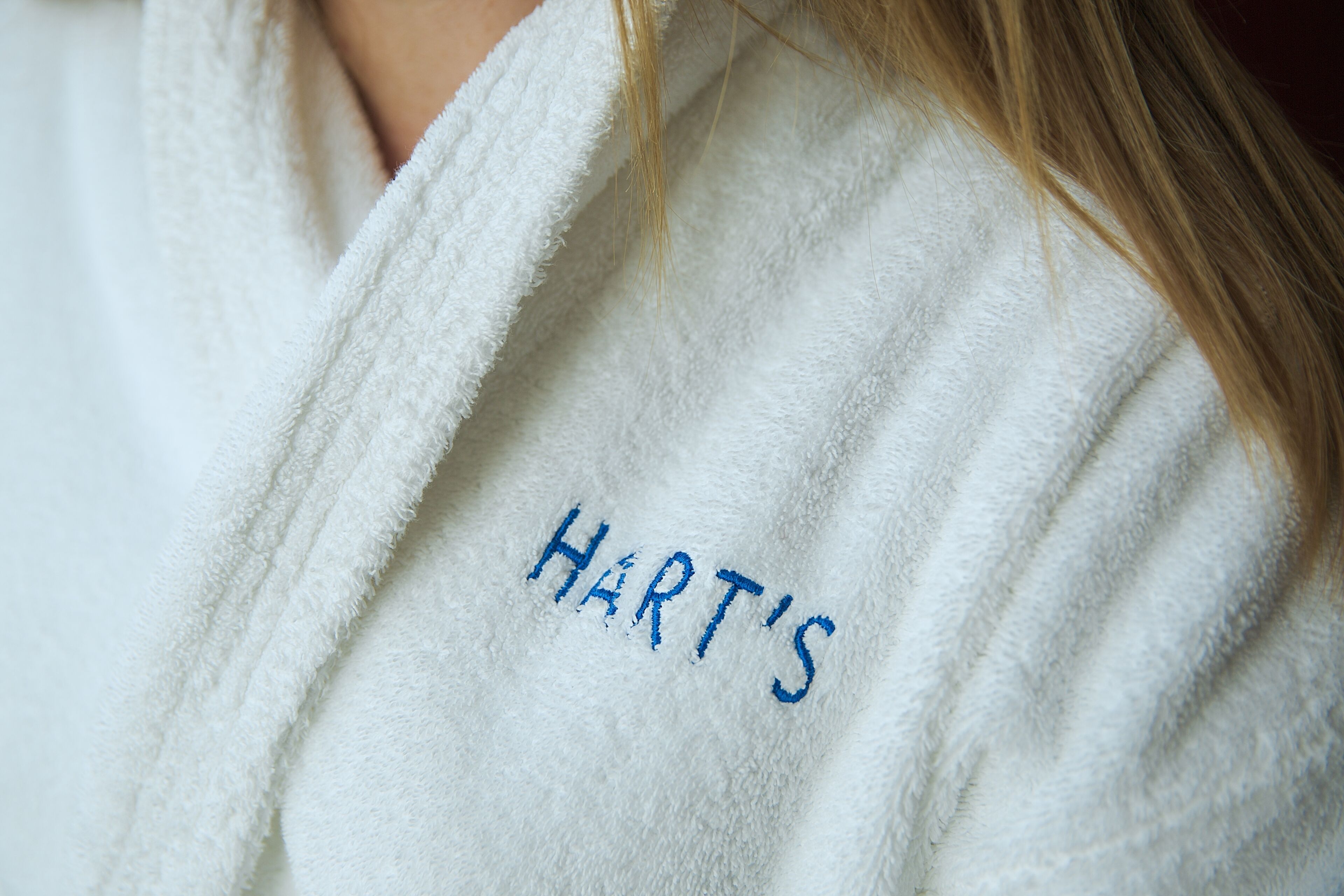 A white towel with the name "HART'S" embroidered in blue.