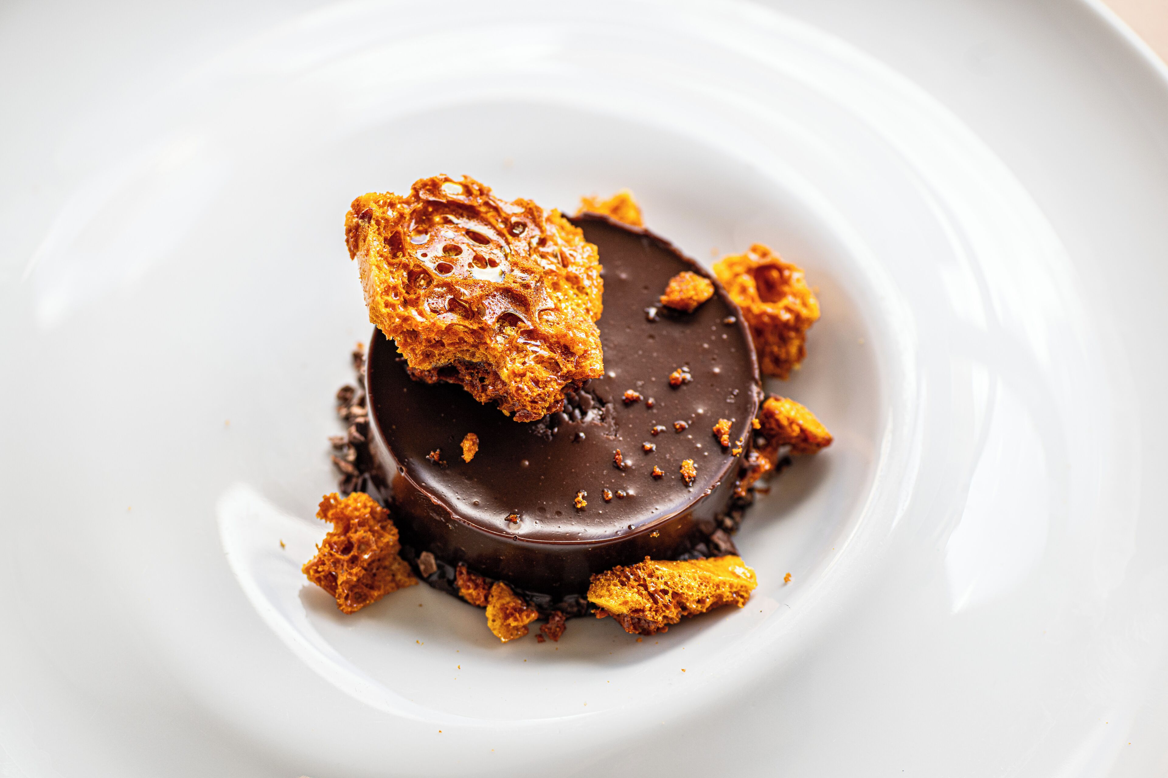 A dessert on a white plate with a chocolate base and caramelized topping.