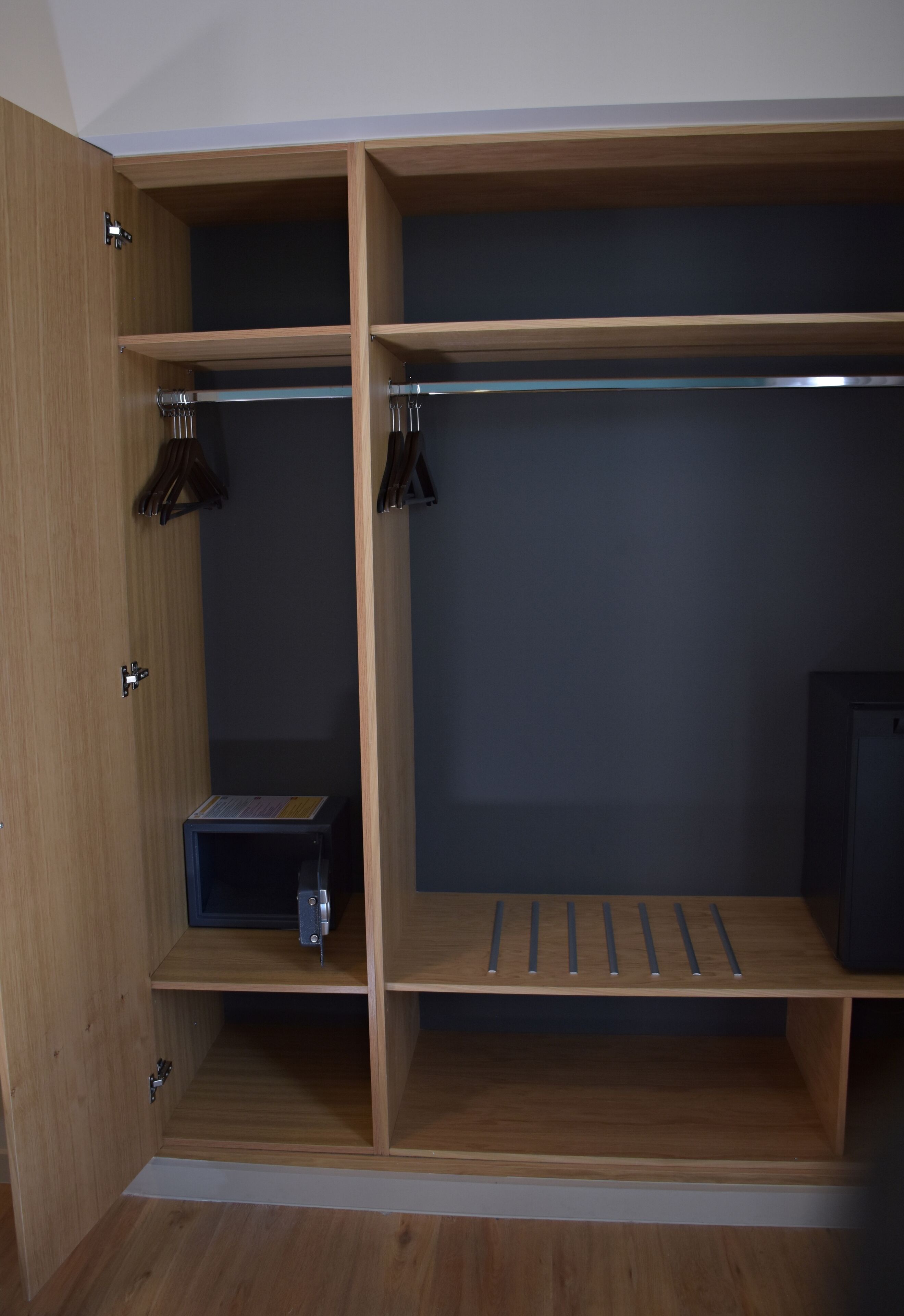 Un armario de madera con varios estantes y espacio para colgar.