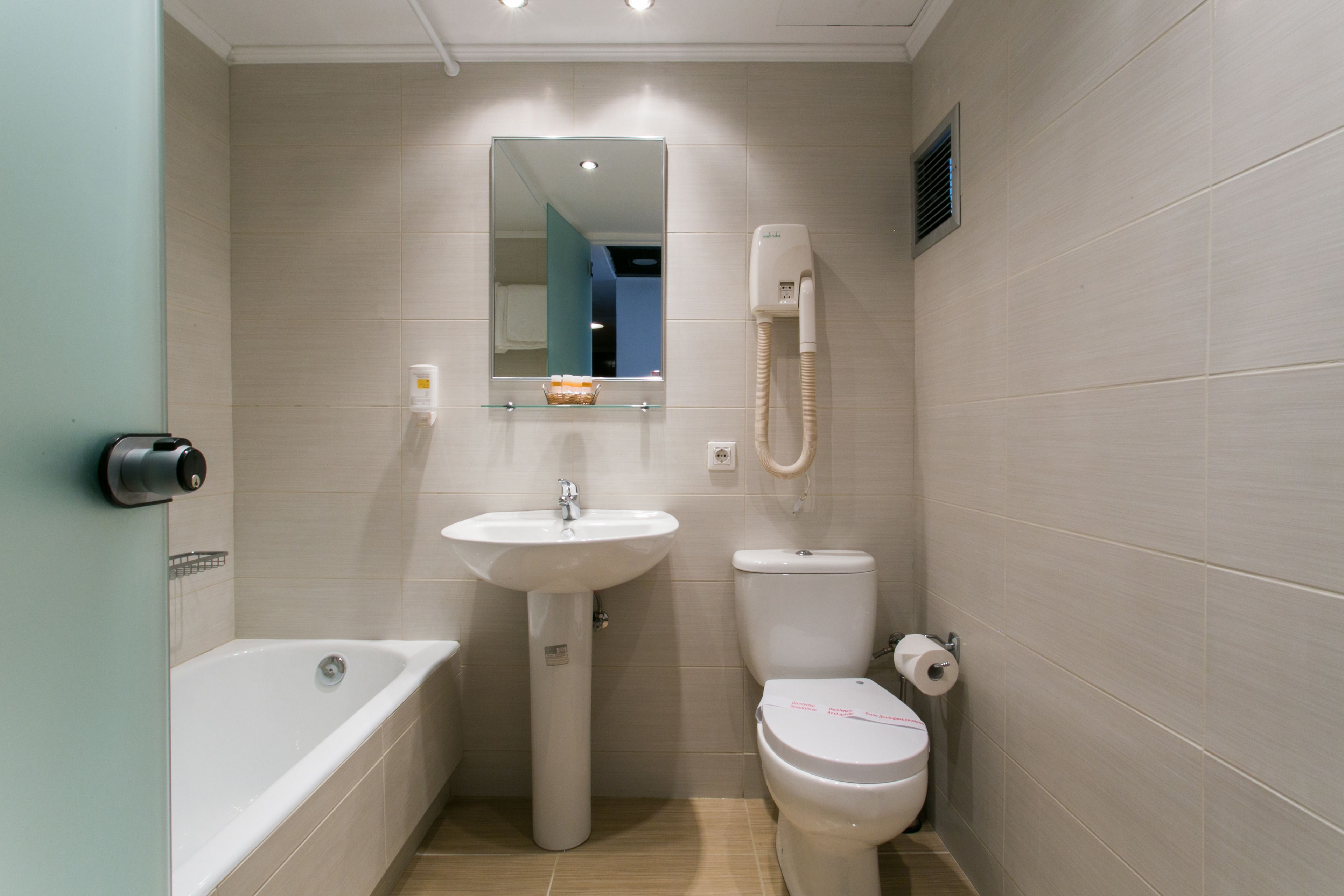 Un baño pequeño con lavamanos, inodoro y bañera.