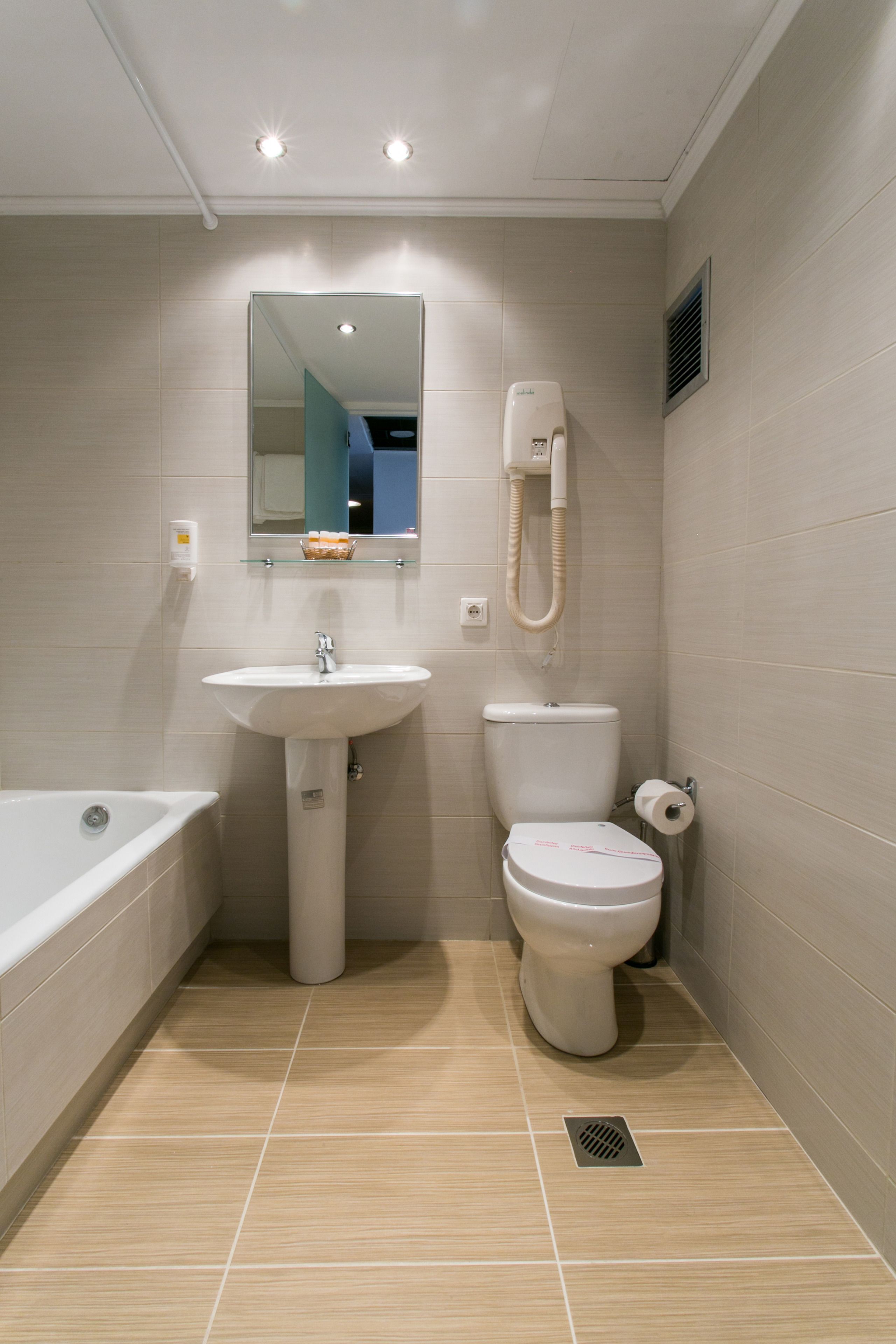 A modern bathroom with a sink, toilet, and bathtub.