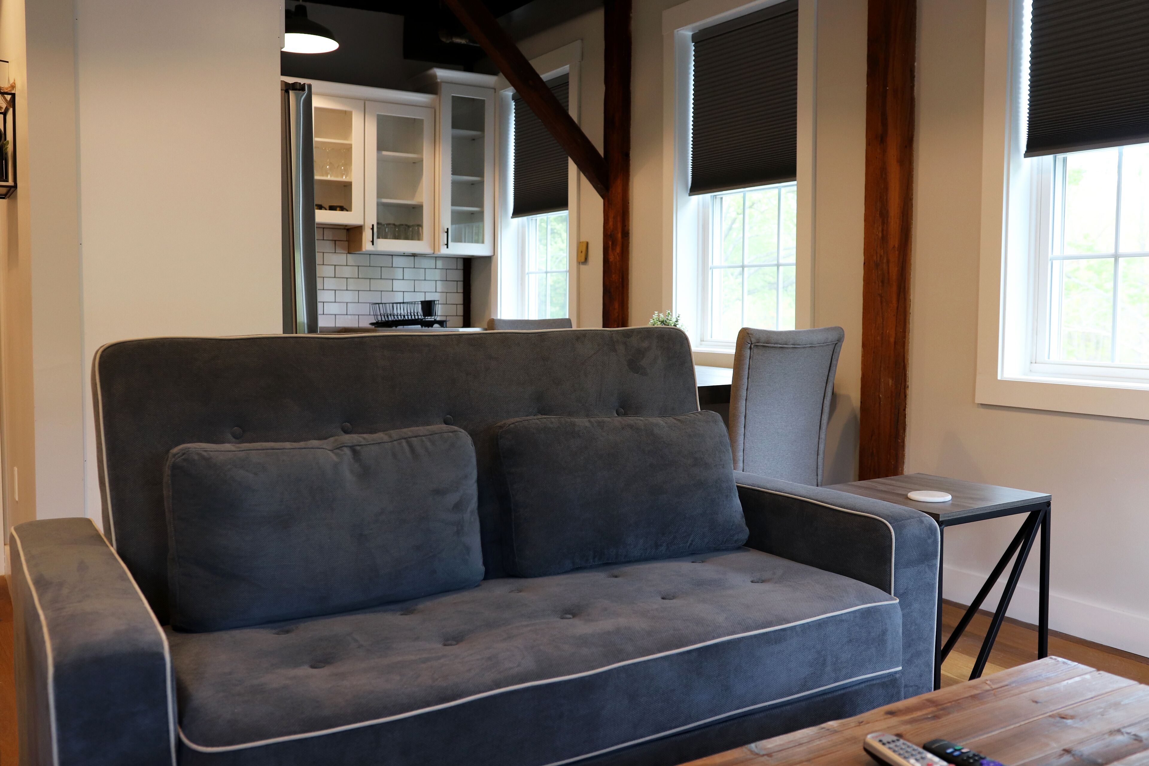 A modern living room with a grey sofa, a small side table, and a wooden coffee table.