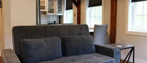 A modern living room with a grey sofa, a small side table, and a wooden coffee table.