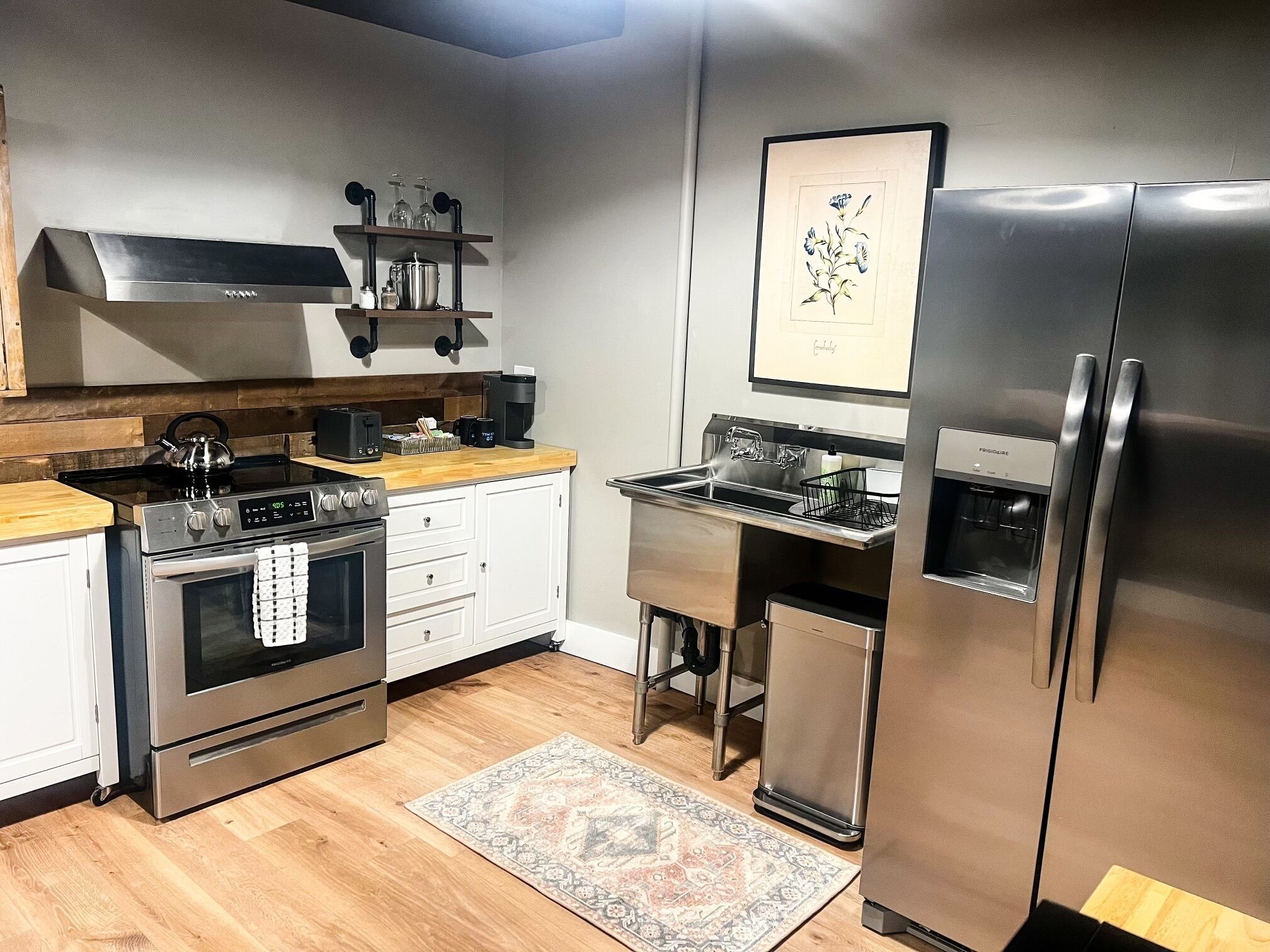 A modern kitchen with stainless steel appliances, a coffee machine, and a water dispenser.