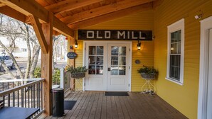 A wooden porch with a sign reading "OLD MILL" above a double door. - Old Mill Inn (Hatfield)