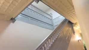 A staircase with white railings and a ceiling with a grid pattern. - St. Charles Hotel (Hudson)