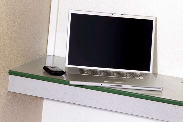 A laptop on a white counter with a green edge.