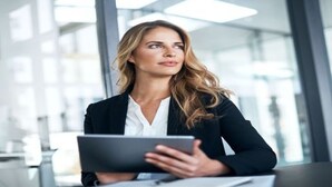 Une femme, dans un cadre professionnel, tenant une tablette.