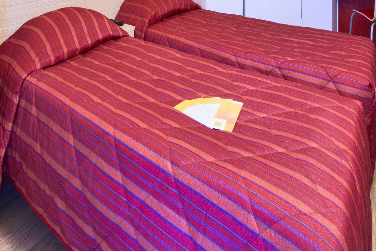 Un lit avec une couvre-lit à rayures et deux oreillers.