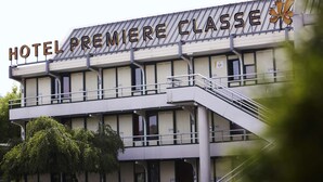 Un hôtel appelé « HOTEL PREMIERE CLASSE », doté d’une architecture moderne, avec un balcon imposant et un escalier menant à l’entrée.
