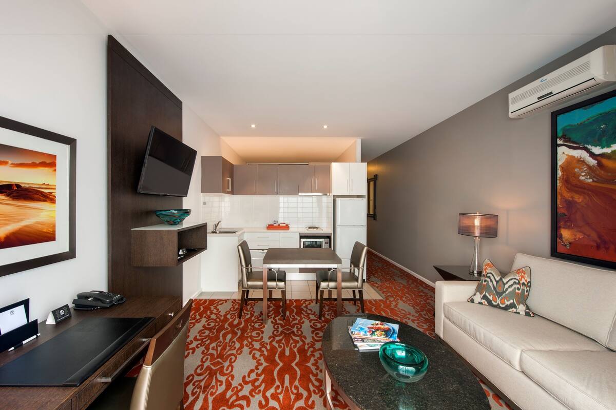 Una sala de estar moderna con un sofá, una mesa de centro y un comedor con sillas y una mesa.