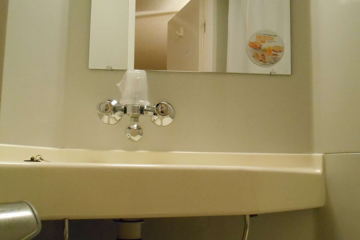 Ein Badezimmer mit Waschbecken, Spiegel und Handtuchhalter.