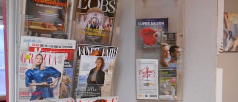 Un atril con varias revistas de Vogue, Cosmopolitan y otras publicaciones.