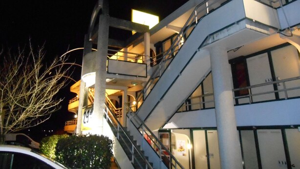 Un edificio de varios pisos con una escalera central y balcones.
