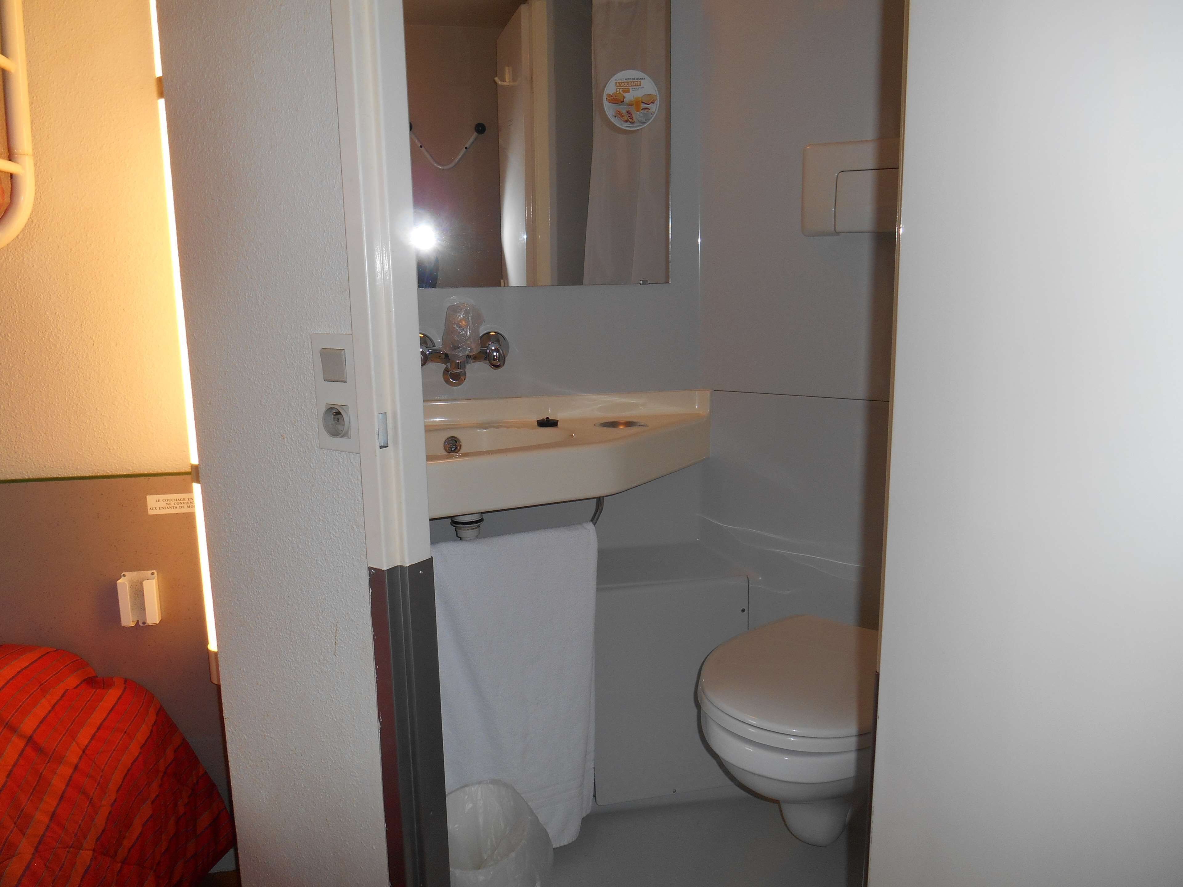 Un baño con lavamanos blanco, inodoro y zona de ducha.