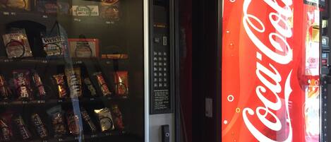 A vending machine with snacks and a Coca-Cola machine.