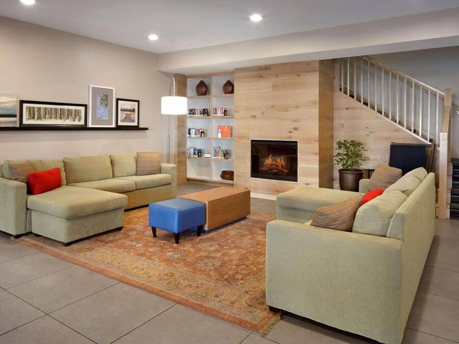 Una sala de estar moderna con dos sofás, una mesa de centro, una estantería y una chimenea.