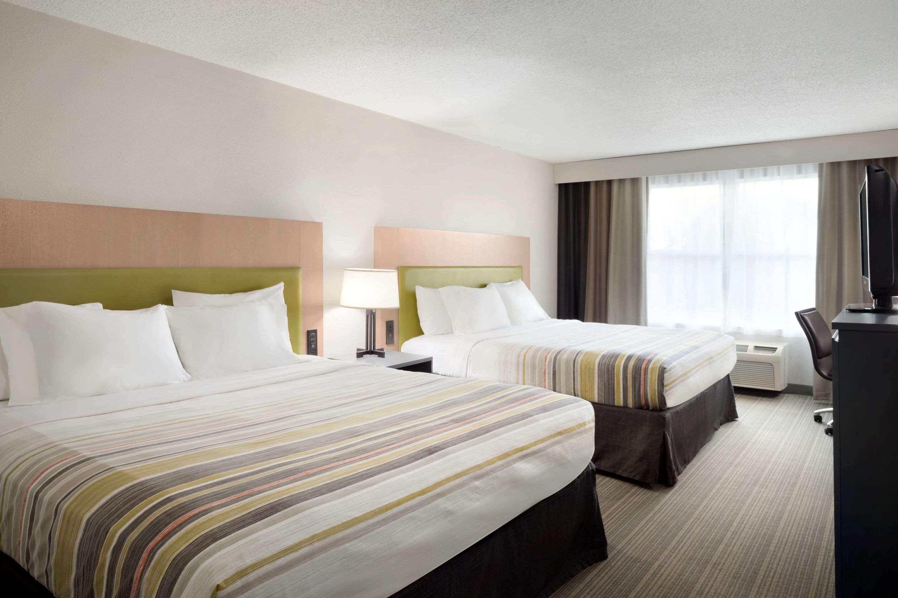 أغطية فراش متميزة وخزنة داخل الغرفة ومكتب ومساحة عمل للكمبيوتر المحمول