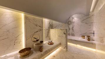 A modern bathroom with marble walls and a built-in sink.
