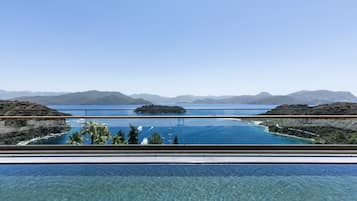 Relax by the serene pool overlooking a tranquil lake and distant mountains.