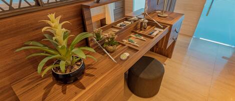 Un mostrador de recepción de madera con una planta en maceta, un espejo y una lámpara.