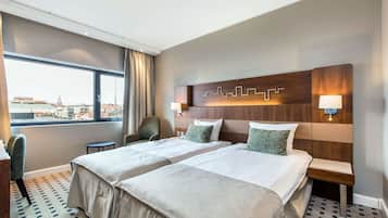 Habitación de hotel con dos camas, vistas a la ciudad y un diseño moderno.